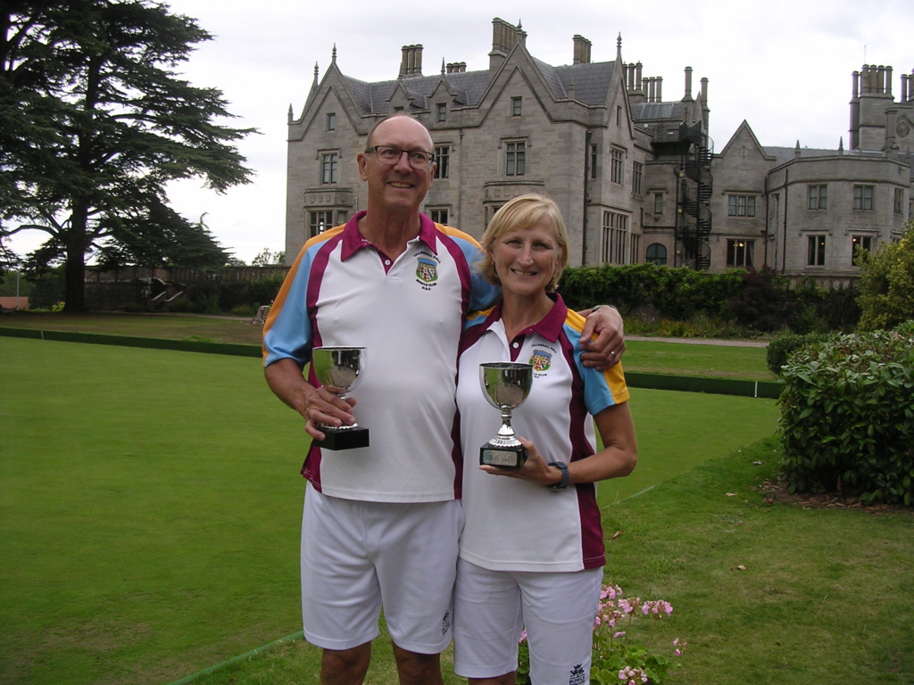 two bowler in club shirt holding two trophies